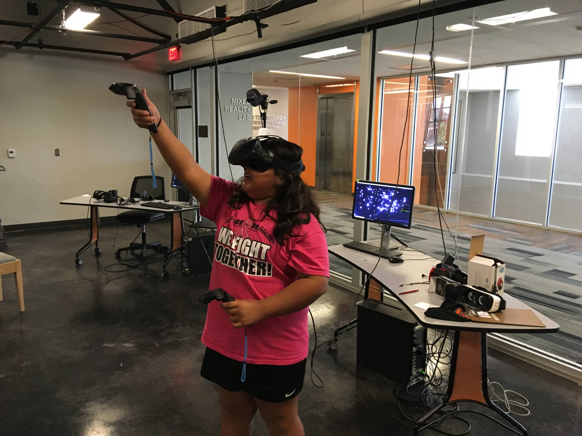 A student uses a VR headset and controllers in the Mixed Reality Lab